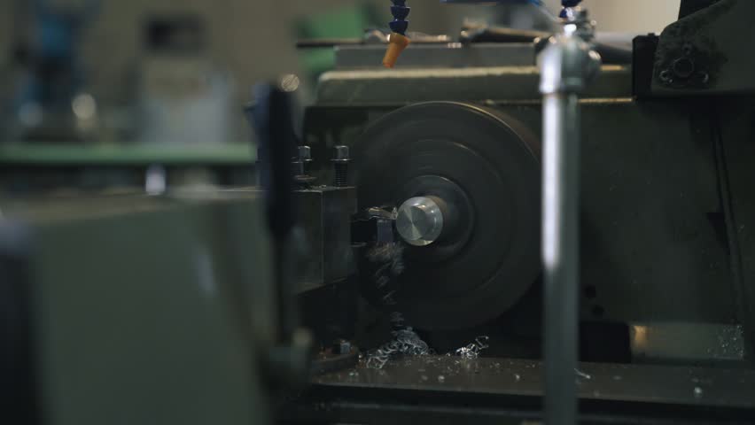Close-up shot of a metal component rotating on an industrial lathe during a precision turning and machining process.
