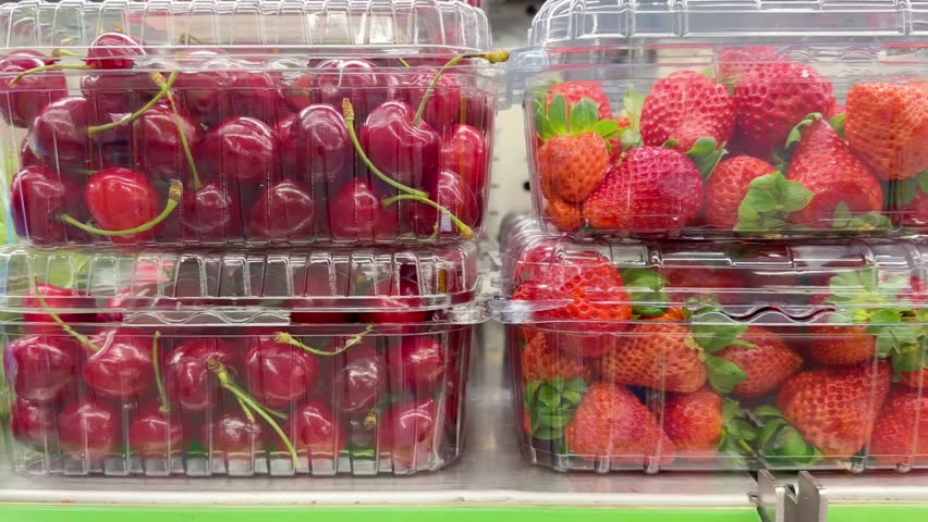 Shelf with Various Packaged Berries – Strawberries, Blueberries, and Raspberries in Plastic Containers in a Supermarket
