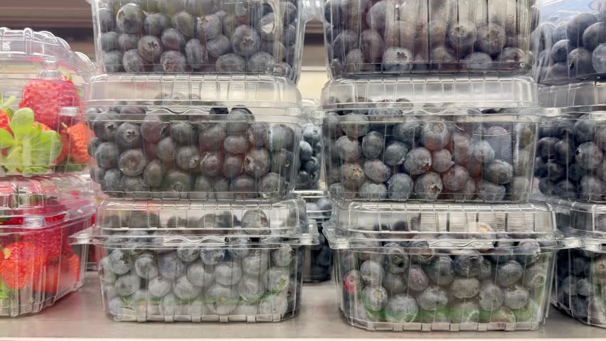 Shelf with Various Packaged Berries – Strawberries, Blueberries, and Raspberries in Plastic Containers in a Supermarket