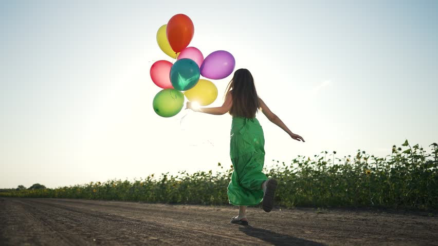Woman dress with balloon in field. Scenic view woman holding colorful balloons walking through open field. Balloon in hand as woman strolls dress. Peaceful moment nature with balloon and flowing dress