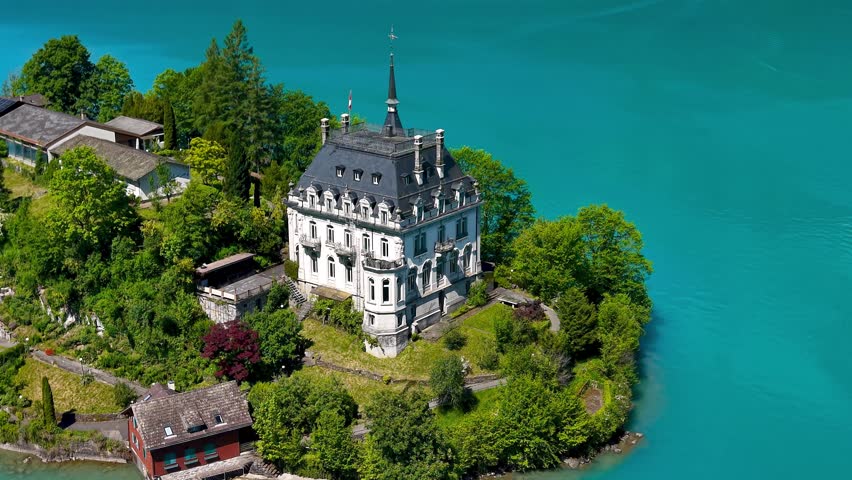 Aerial view of the historic Seeburg castle on the turquoise shores of Lake Brienz, Switzerland.
