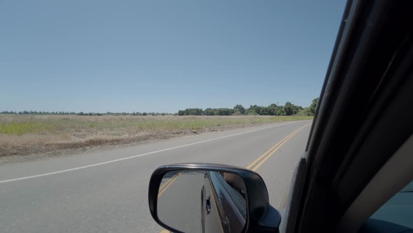 POV driving on a rural two-lane country road on a sunny day