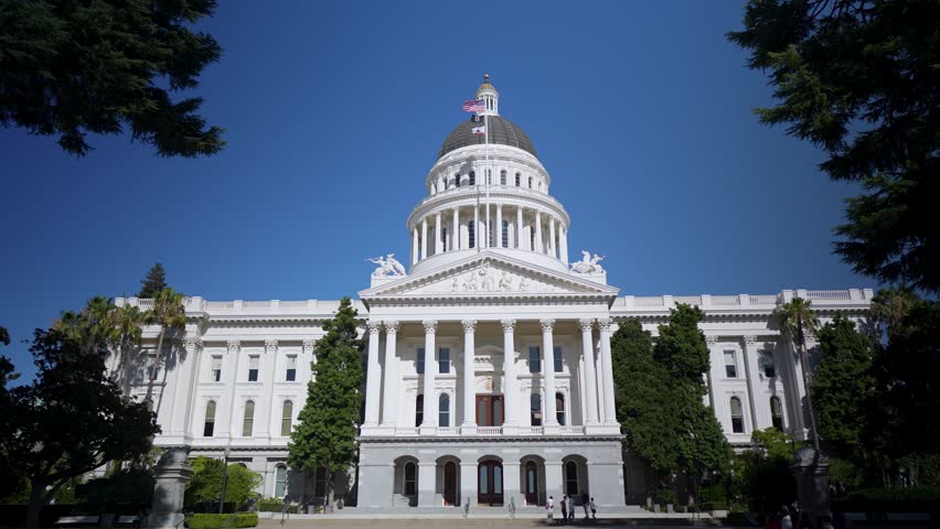 Enjoy views of California State Capitol in Sacramento with clear skies and people visiting this historical government building.