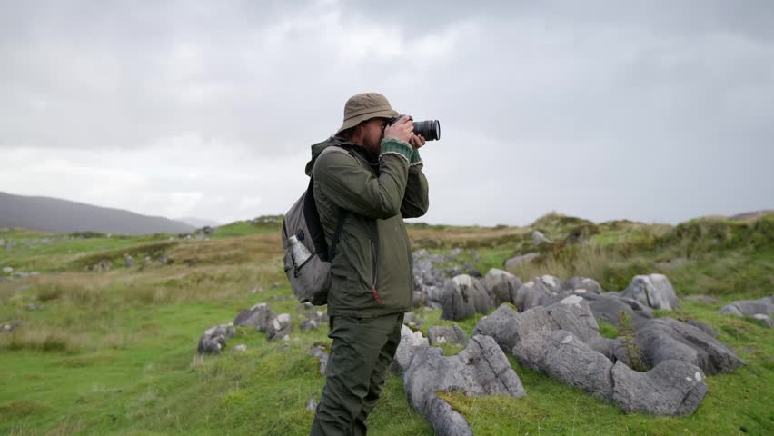 A man taking a photo while hiking through the rugged Scottish landscapes of the Isle of Skye Adventure