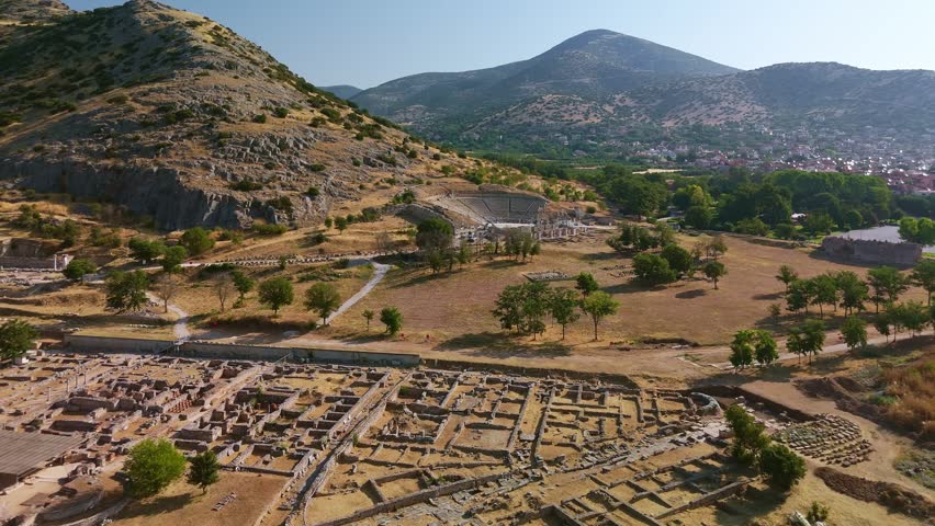 Aerial view of the UNESCO World Heritage site of Philippi, Greece. The ancient theater, Roman forum ruins, and the archaeological museum are nestled against the backdrop of the Marble mountains.