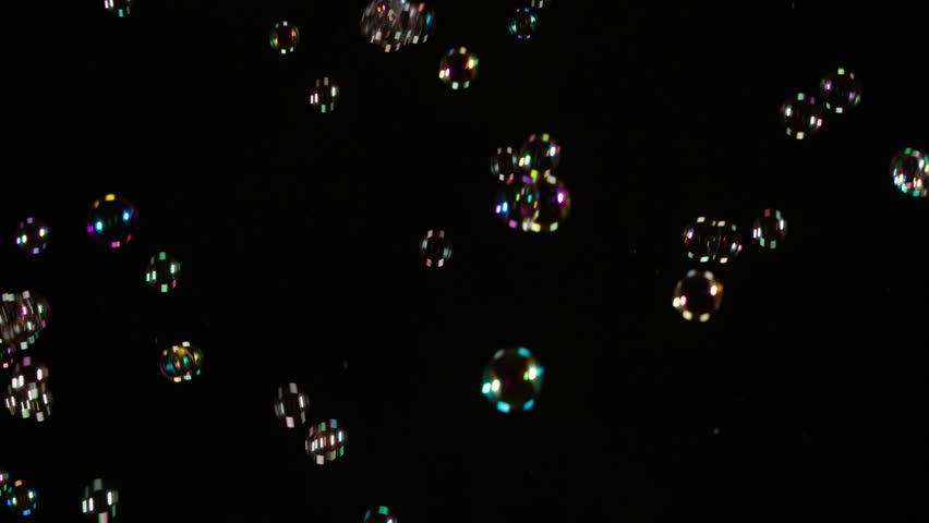 Soap Bubbles Floating on Black Background. A large number of soap bubbles moving in one direction against a black background. Great for use in blending