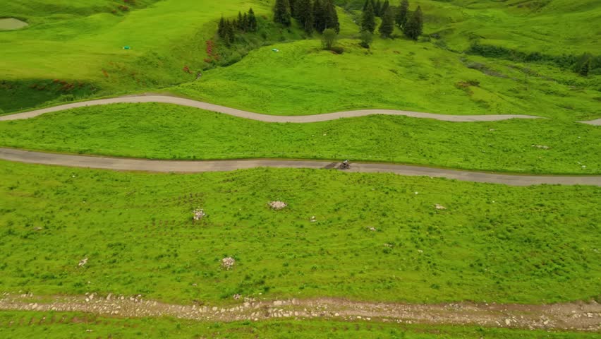 Cyclist on gravel road amidst stunning alpine scenery of Fellhorn and Kanzelwand in Germanys Bavarian Alps. Aerial view of summer adventure with green mountains, trails, and breathtaking panoramas. 