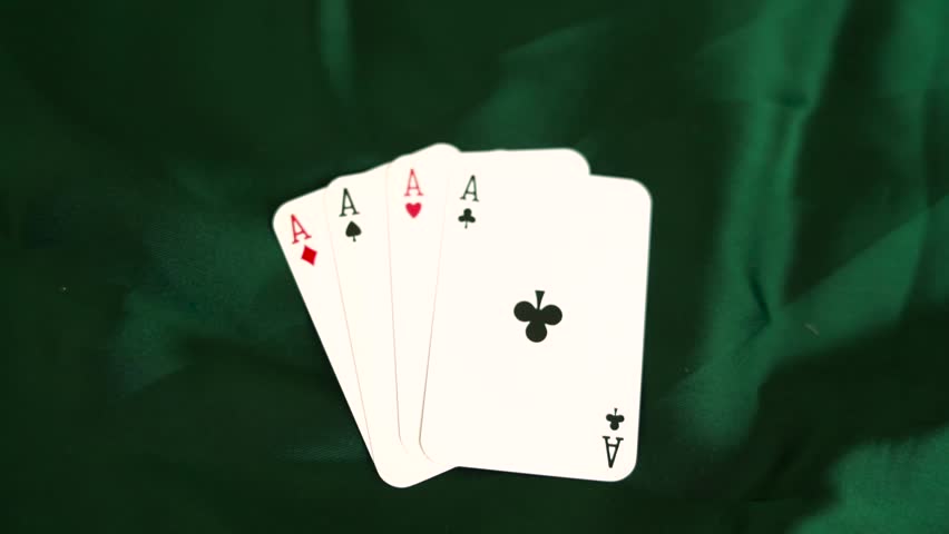 Four aces playing cards arranged in a fan on green velvet fabric background poker game gambling