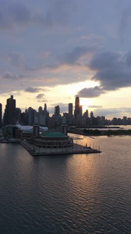 Downtown Chicago skyline at sunset reflecting on Lake Michigan with Navy Pier and John Hancock Center, city