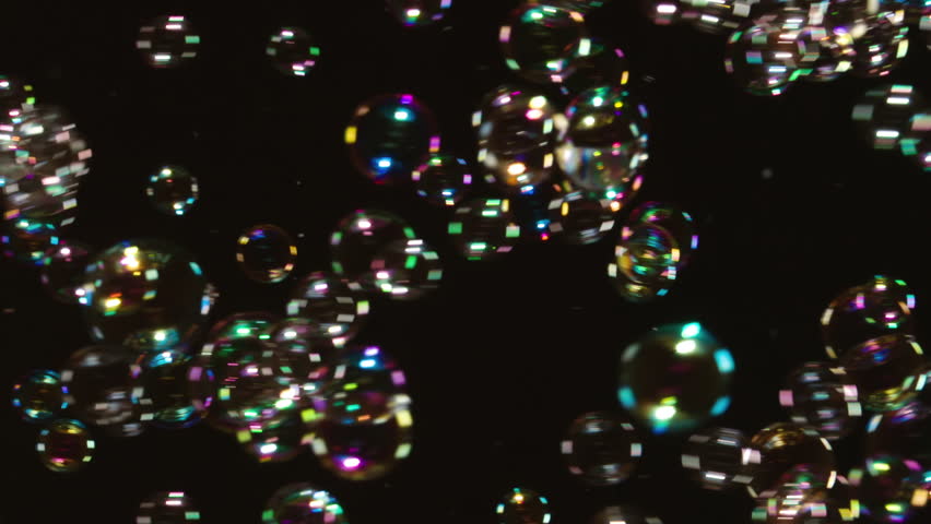 Many Soap Bubbles Floating on Black. A large number of soap bubbles moving in one direction against a black background. Great for use in blending