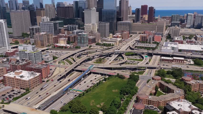 Urban metropolis showing elevated interstate highways and traffic congestion with Chicago skyline, skyscrapers, Lake Michigan and blue line train running into downtown