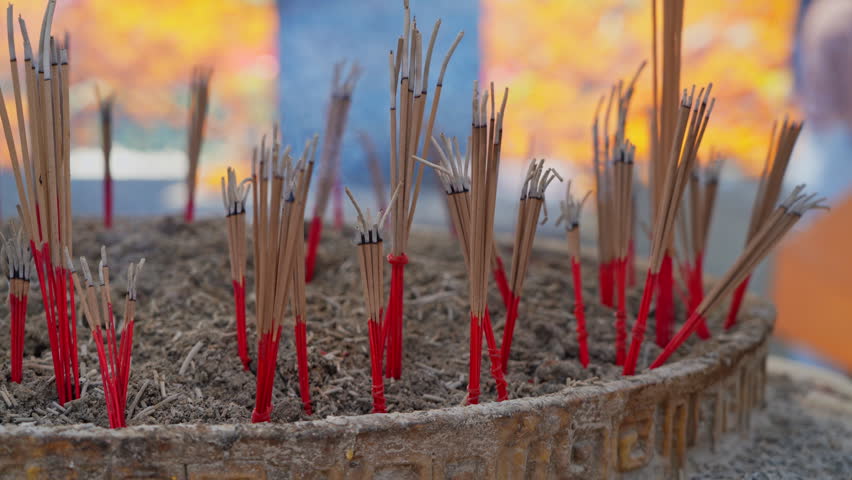 Slow motion of smoke rising from incense pot at Buddhist temple.