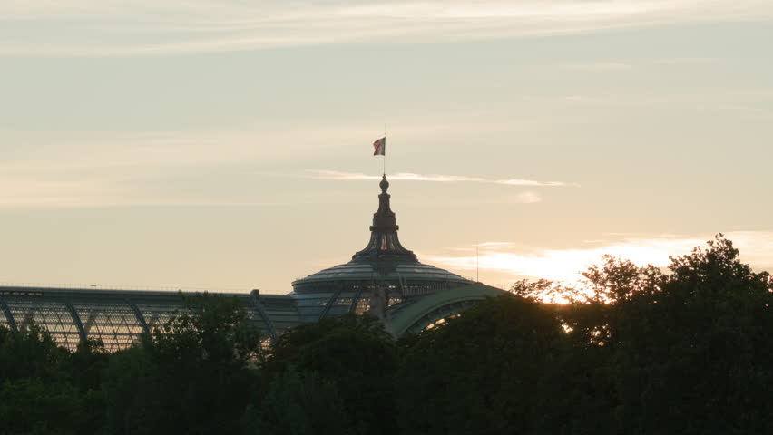 French Flag Waving Atop the Glass Dome During a Brilliant Golden Hour Sunset in Paris