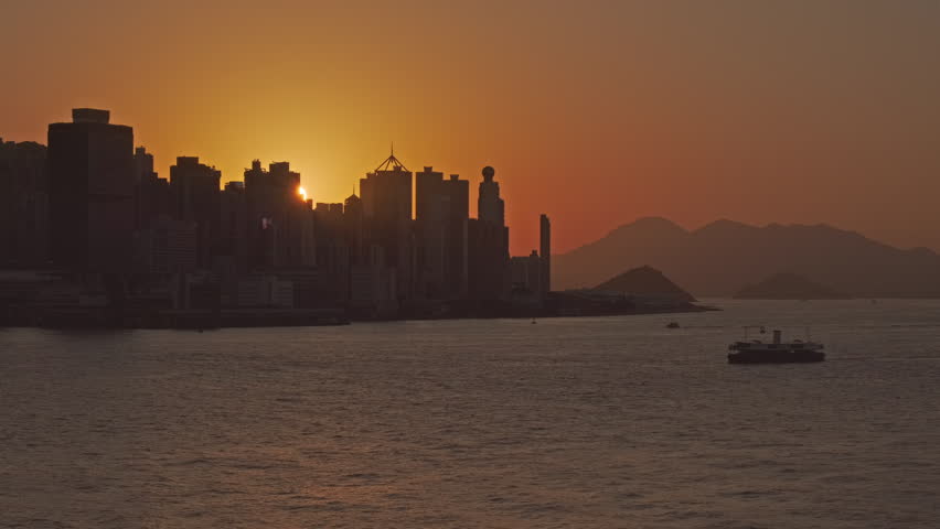 Hong Kong at sunset. Boats in Victoria Harbour and Hong Kong Central, 4k