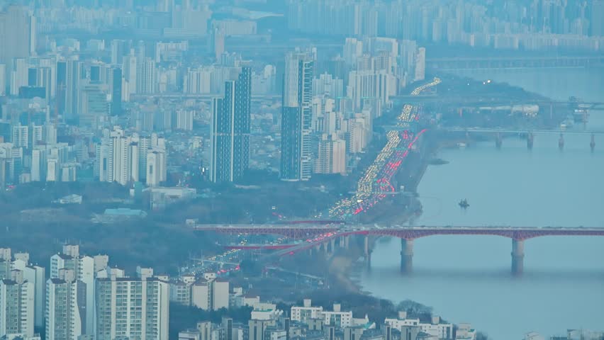 Distant Urban High Rises and Bridges Over Wide River at Dusk