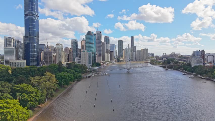 Drone aerial view of Brisbane CBD, Brisbane River and Kangaroo Point Bridge with City Botanic Gardens, ferries and boats on a sunny day in Queensland.
