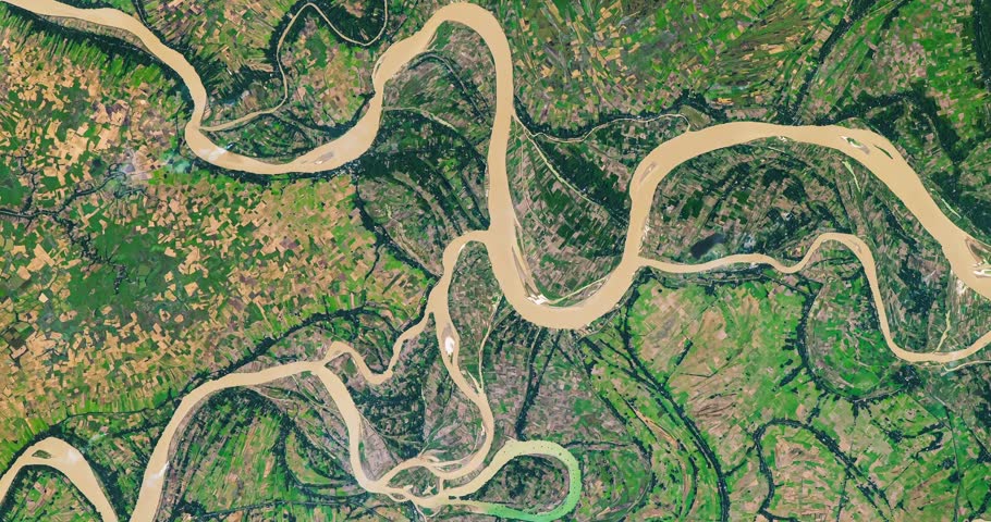 Panoramic shot on meanders of river in agricultural region with many parcels of land. Camera is moving right and down. Animation based on image by NASA