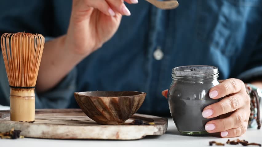 Woman Measures Tea For Making Blue Matcha Tea Into A Bowl