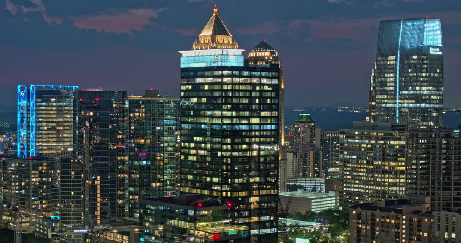 Atlanta Georgia Aerial v899 hyperlapse zoomed shot, flyover Piedmont Park capturing illuminated Midtown cityscape, light up high rise buildings at dusk night - Shot with 5k Camera - July 2023