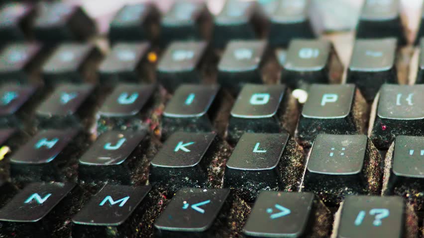 Dirty computer keyboard covered in dust and food debris workplace hygiene concept