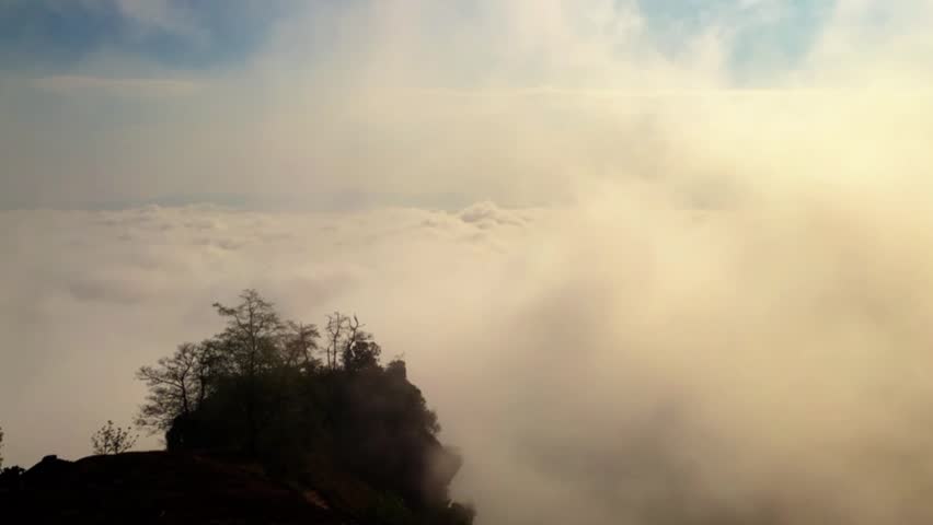 A breathtaking panoramic view showcases a magnificent sea of clouds stretching endlessly beneath a clear blue sky.
