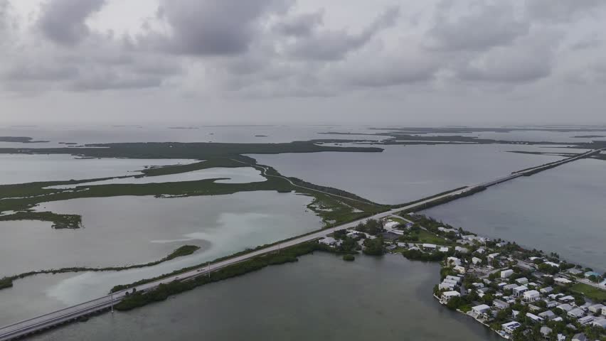 Aerial view of turquoise ocean, mangrove island and Overseas Highway in Florida Keys with boats and clear water. g.