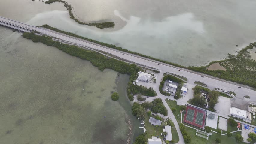 Aerial view of turquoise ocean, mangrove island and Overseas Highway in Florida Keys with boats and clear water. g.