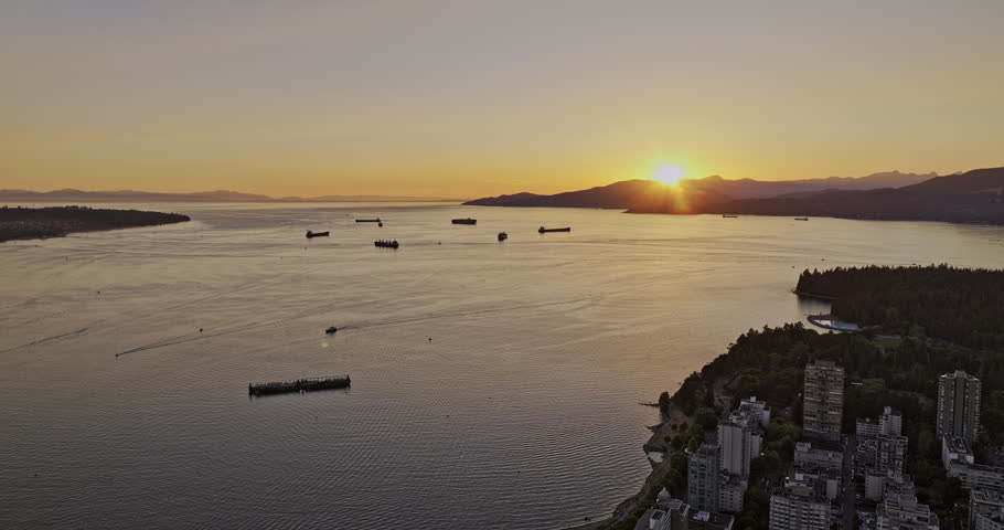 Vancouver BC Canada Aerial v62 reserve flyover West End neighborhood capturing English bay beach, Burrard inlet, mountain and views of the sunset over the bay - Shot with 5k Camera - July 2023