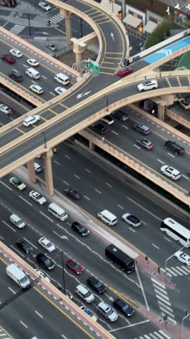 Urban infrastructure. Multi-level highway interchange with cars driving along curved flyovers and multi-lane asphalt roads in Dubai, United Arab Emirates.
