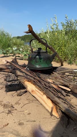 Tourist kettler on bonfire, cooking in the hike, outdoor activities. Old kettle is burning at the stake outdoors.