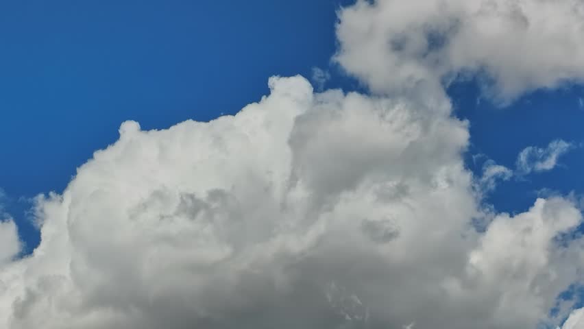 Clouds floating in the blue sky over the USA. The sky is mostly clear, with some fluffy clouds adding texture to the view.