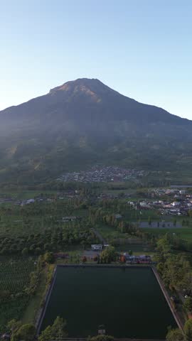 Aerial View of Majestic Volcano, Village and Pond in Golden Hour Landscape