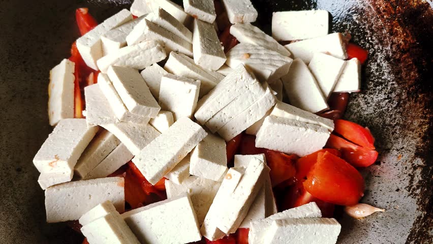 Frying tofu with  tomatoes in pan, indoor Chiangmai Thailand.