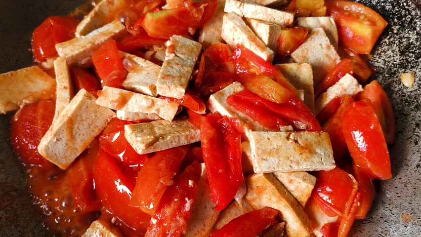 Frying tofu with  tomatoes in pan, indoor Chiangmai Thailand.