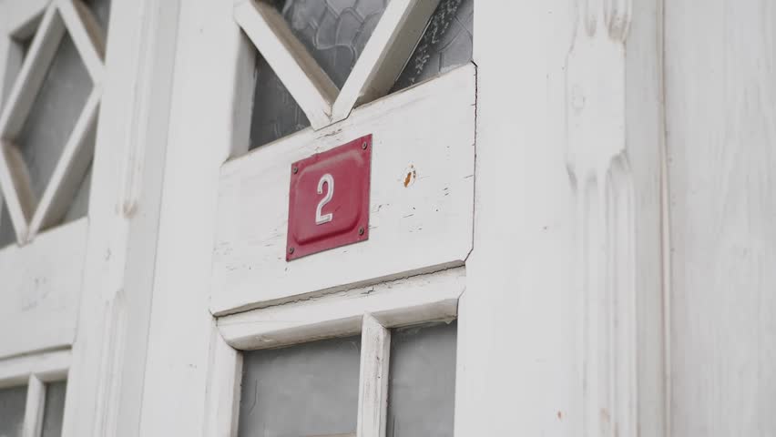 Close-up of a weathered door featuring the number two.