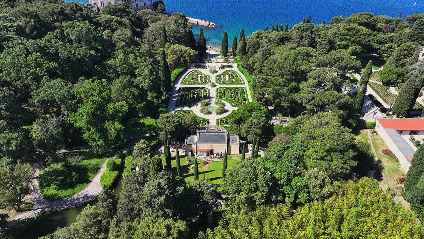 Trieste, Italy - 4K Flying above the beautiful Miramare Castle (Castello di Miramare) by the Gulf of Trieste on a sunny summer day with blue sky and turqoise sea water