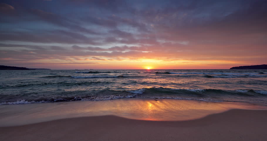 Scenic sunrise over calm sea waves on a sandy tropical beach Dominican republic