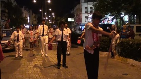 Kas, Turkey – May 25, 2013: Celebration of the Youth and Sport Day – parade on streets of evening town, school children march, audio