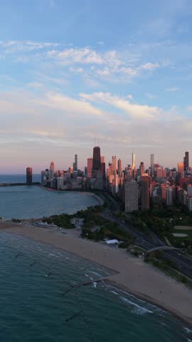 Urban landscape revealing Chicago skyline with John Hancock Center and Lake Michigan shoreline, showing Oak Street Beach and Lake Shore Drive in vertical