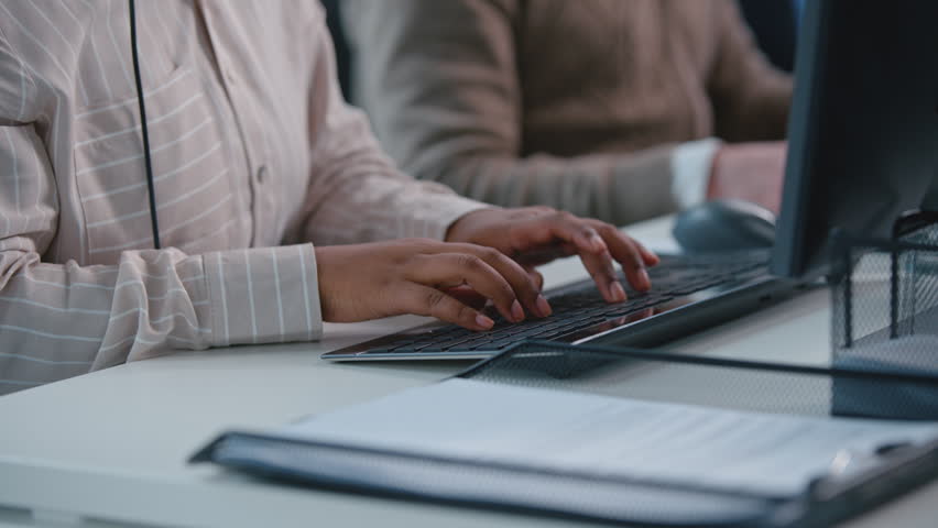 Close up concentrated multiethnic team operators in call center talking with headsets. Serious multiracial callcenter business agents two diversity men and Arabian saleswoman talk to customers advice