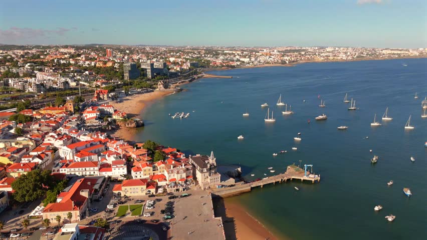 Aerial View of a Bay Dotted With Sailboats Near a Coastal Town