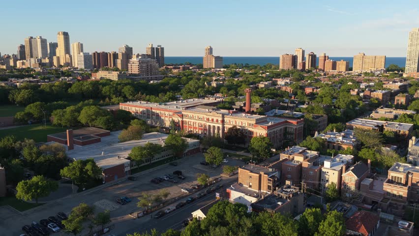 Urban landscape showing Lincoln Park High School and lakeshore skyline in Chicago, Illinois during a sunny afternoon, with city buildings and Lake Michigan in sight