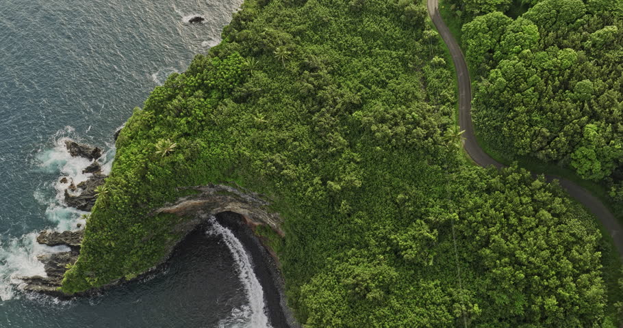 Maui Hawaii Aerial v7 slow motion flyover Pailoa point capturing rocky cliffs, sea cave, lush vegetations and scenic Hana highway drive along the coastline - Shot with 5k Camera - December 2022