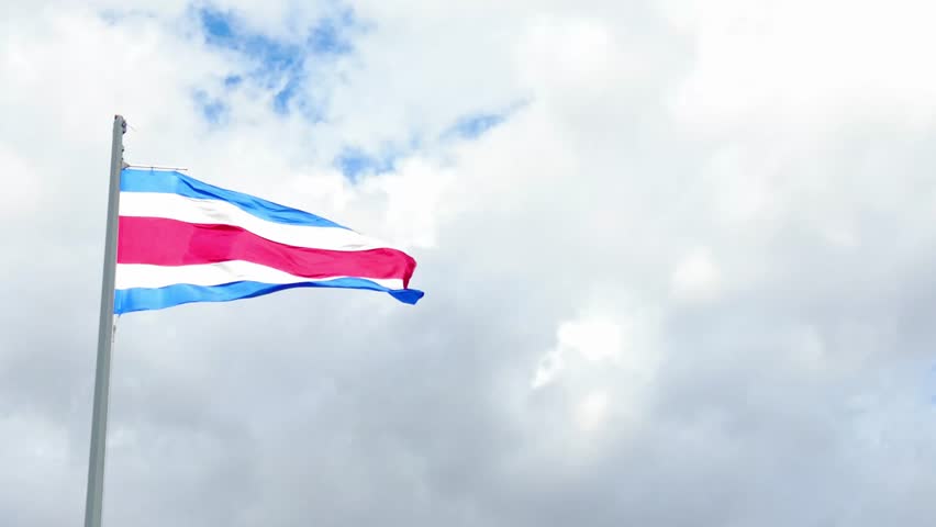 National flag of costa rica flying on a flagpole against a cloudy sky