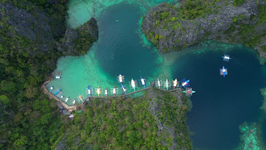Coron Palawan lagoon with docked outrigger boats. Lovely aerial view drone