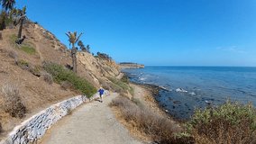 Shot of a mature man as he walks up a steep path from the rocky beach. This clip captures the beauty of a San Pedro Beach and illustrates typical fitness regimen of aging adults.