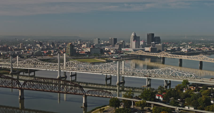 Louisville Kentucky Aerial v53 flyover shore of Jeffersonville capturing freeway traffic on the bridges over Ohio river and downtown cityscape on the skyline - Shot with 8k camera
