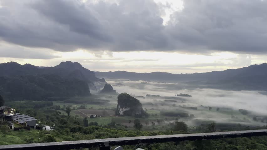 Stunning aerial landscape of mountains surrounded by heavy fog under cloudy sky