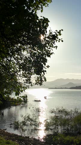 Peaceful Sunrise at Mountain Lake with Boat Silhouette