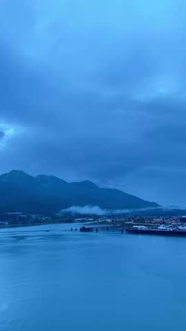 Blue hour in Alaska with mountains, fog and calm ocean waters

Peaceful blue hour scene in Alaska with mountains, fog over the water, calm ocean and cloudy sky, serene nature background